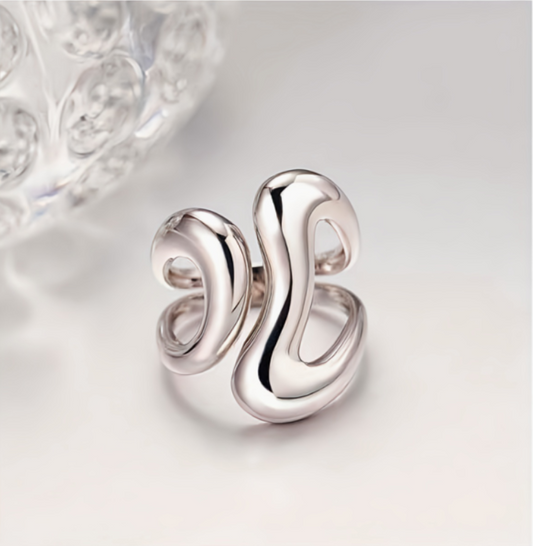 Silver earring on a light gray background